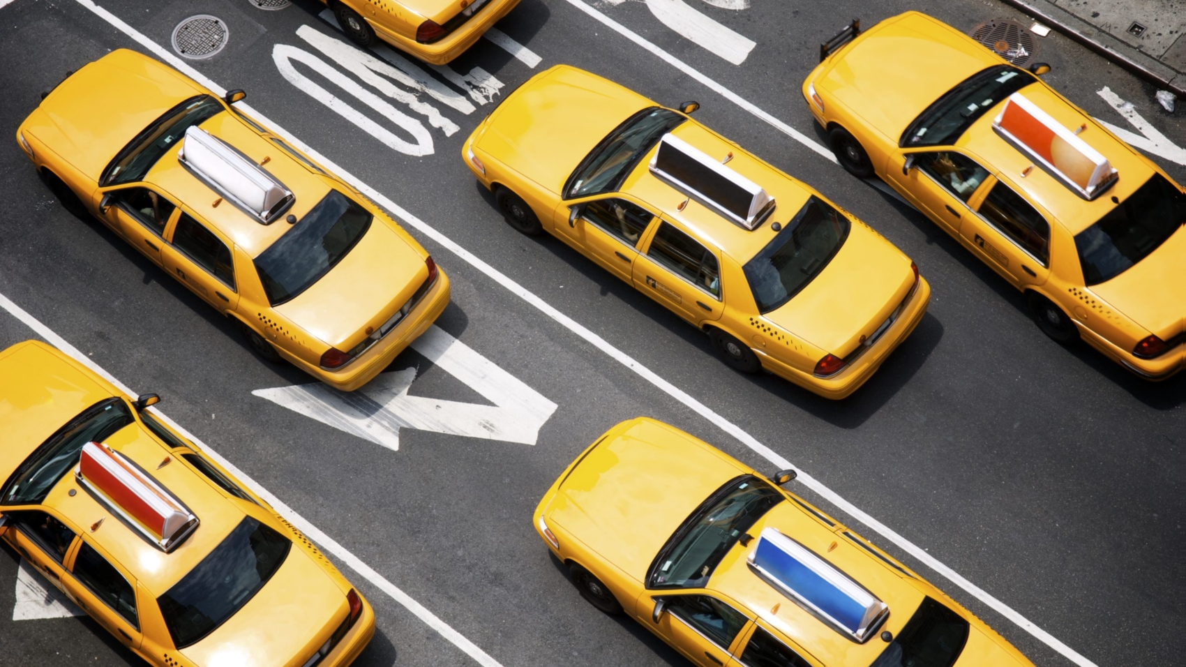 Fleet of yellow taxi cabs make their way down the street of Broadway in New York City in view from above